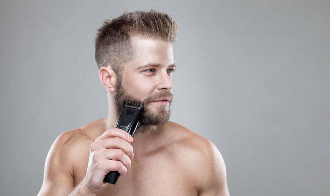 bearded man trimming his beard