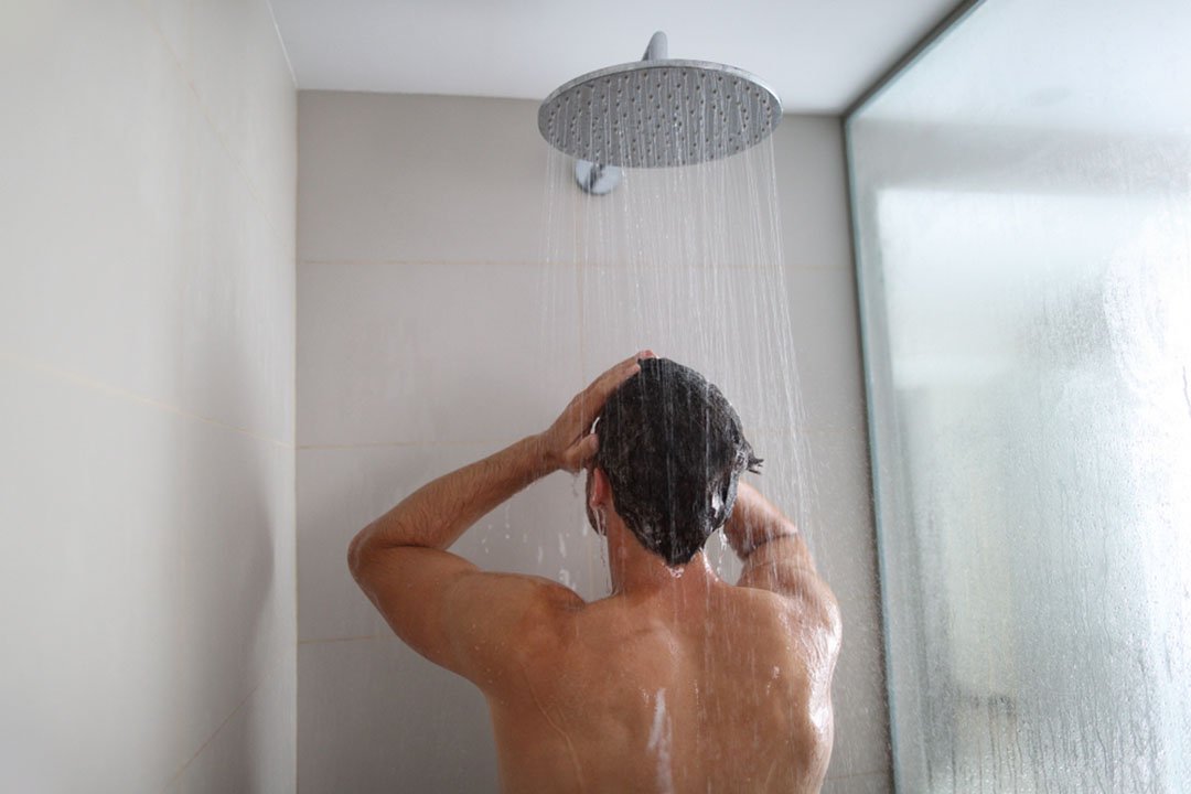 man standing under shower head