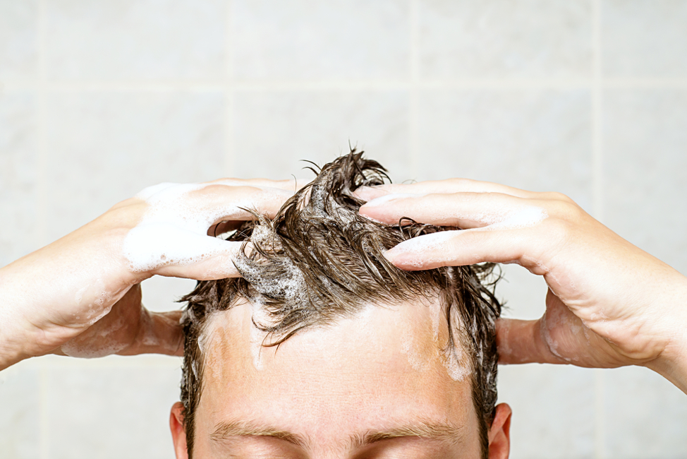 man washing his hair with shampoo